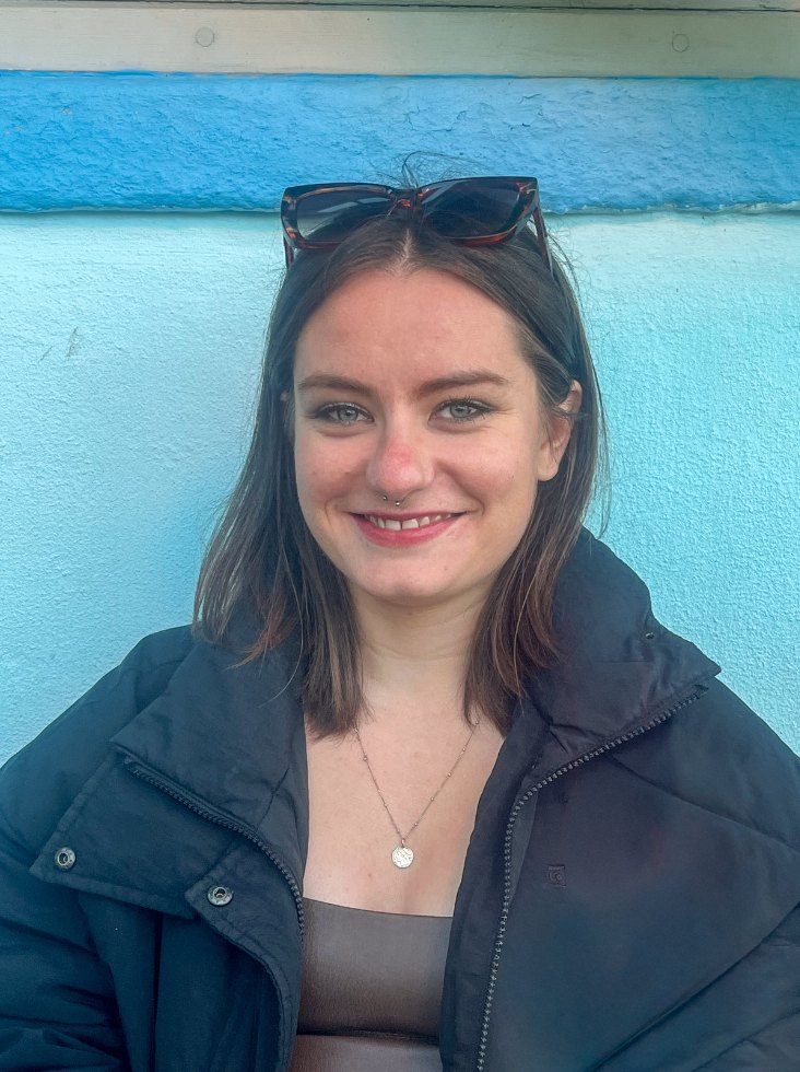 Molly Stacey smiling in front of a blue wall
