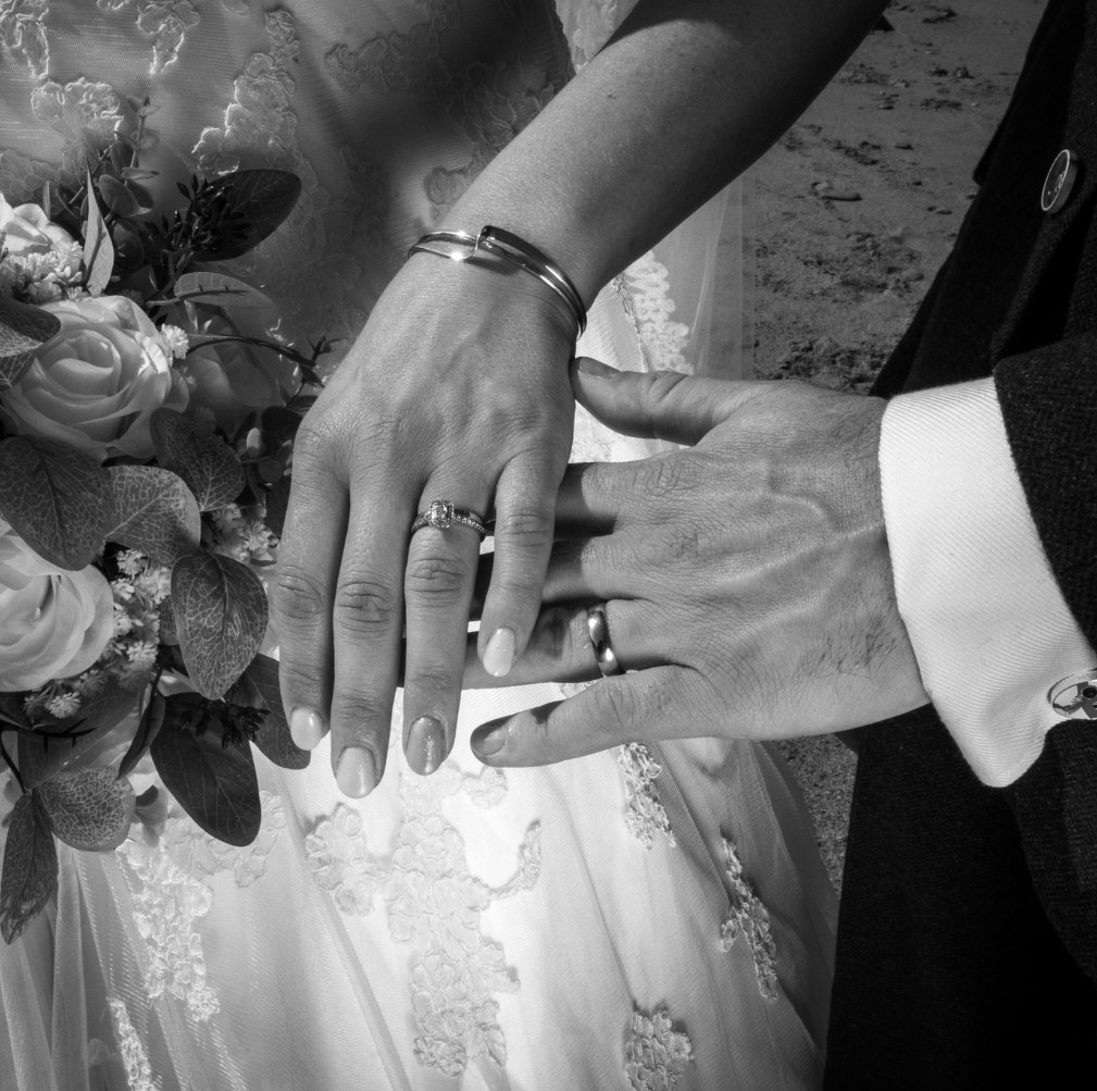 Newlyweds' hands and rings in black and white